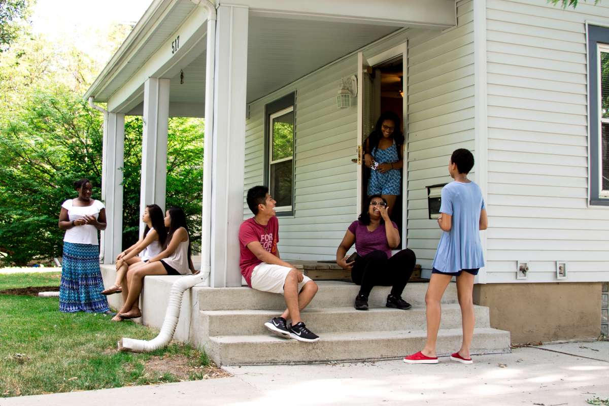 Students on porch of a white house