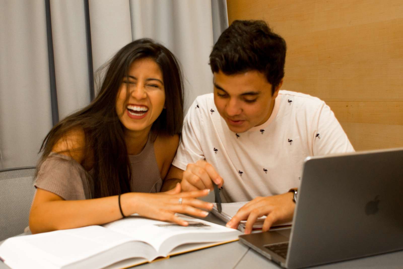 Two students studying together and laughing